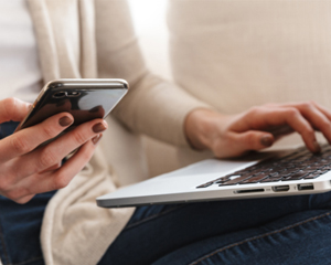Woman with a phone and laptop