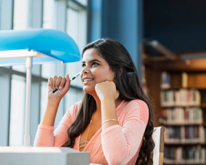 Young woman with a pencil thinking about the library's databases