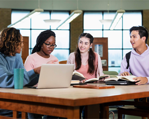 Group of teenagers working on homework at the library