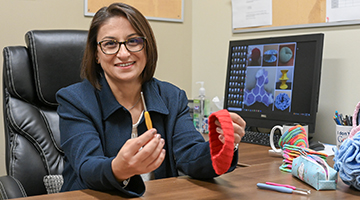 Dr. Aslan holds the tools of her art