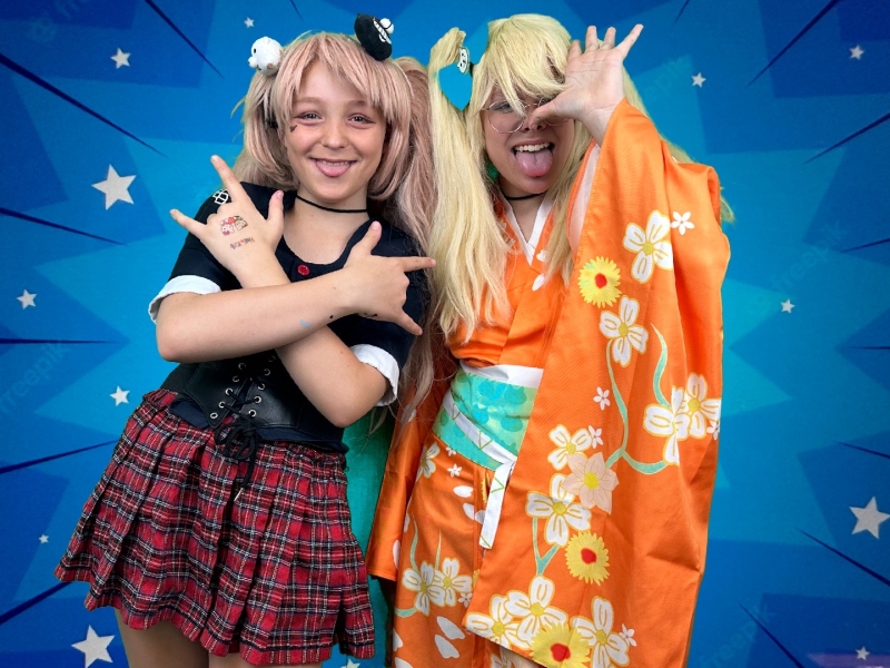 Anime cosplayers posing in front of a superimposed background