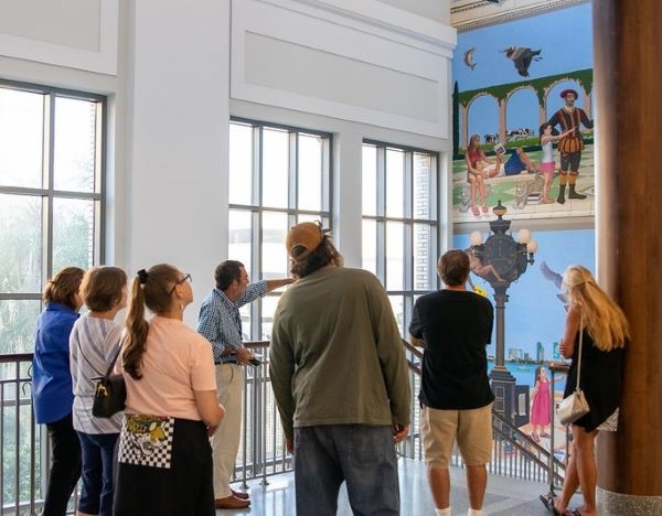 photo of a volunteer docent giving a tour to art lovers