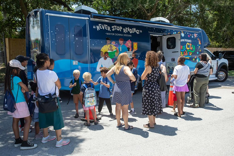 people waiting to board the bookmobile