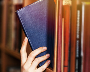 photo of a book being taken off of a bookshelf