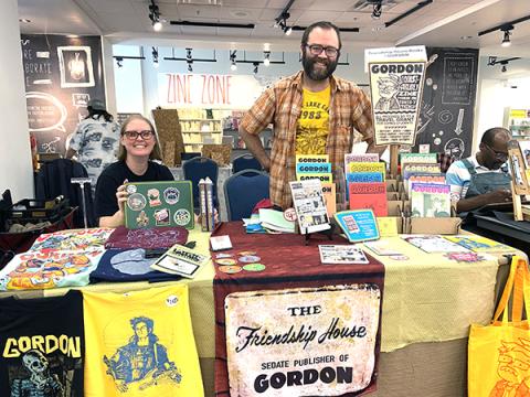 two people at a table of zines
