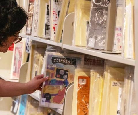 person browsing the zine collection at Main library