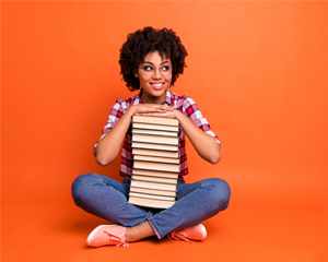 photo of a woman holding a stack of books